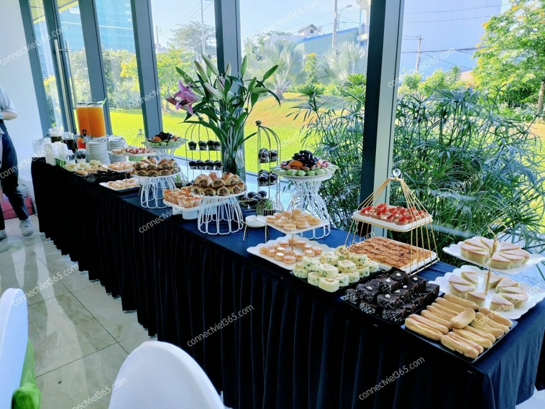 Bàn teabreak tổng thể với khay gỗ, hoa tươi và trà cà phê
